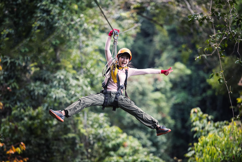 Young woman zip-lining in the jungle